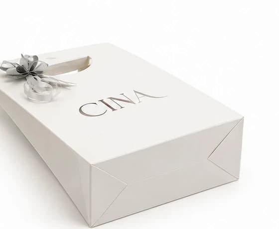 Detalle del packaging de Cina Accesorios apoyado de costado