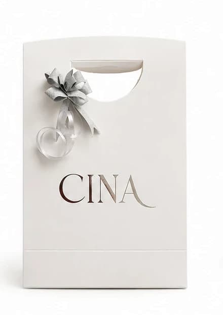 Packaging de Cina Accesorios: bolsa blanca con moño plateado y el logo CINA